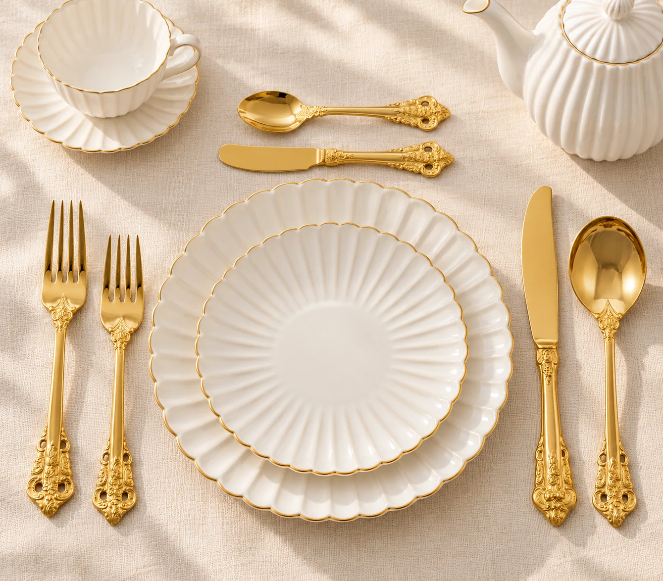 Table-setting concept pairing ornate gold-coloured flatware with white fluted ceramic dinnerware