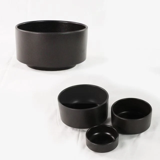 Dark cylindrical ANELLO side-dish bowls in a group and side view